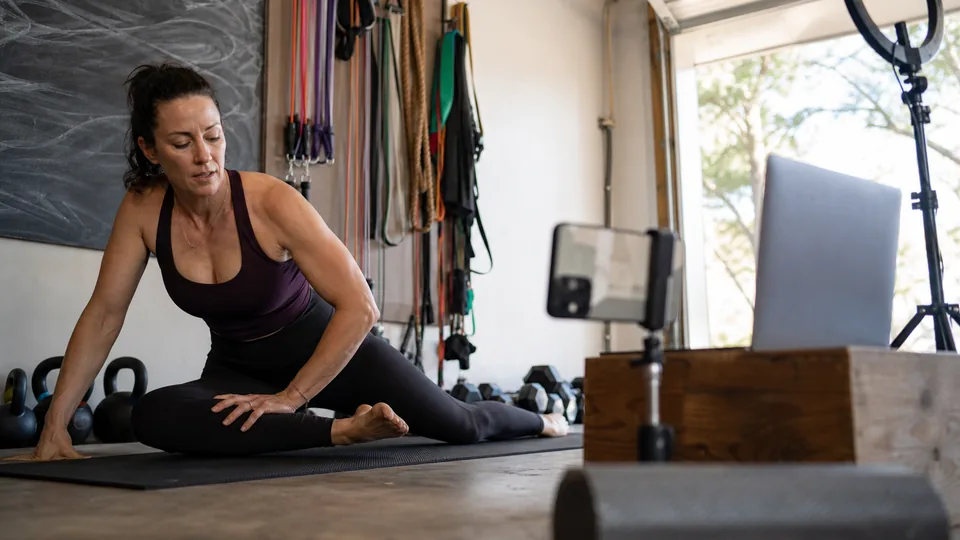 Fitness coach teaching a paid live online mobility class from her home studio